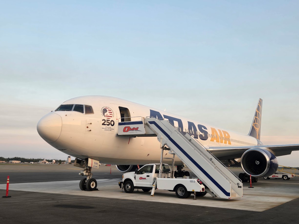 Atlas Air shows the America 250 celebration on the side. Omni stairs are pulled up to the door.